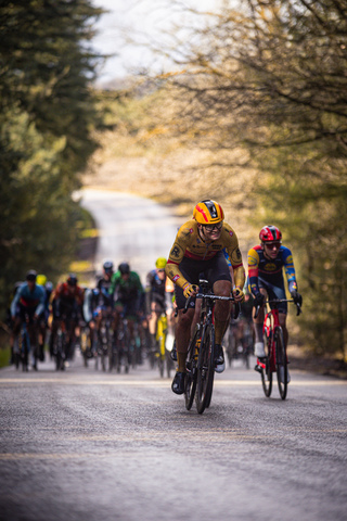 A group of cyclists race down a street during the Olympic Tour.