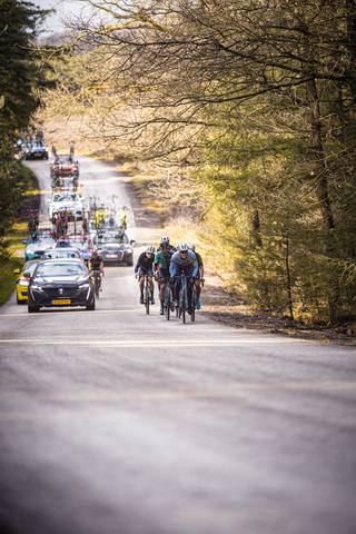 A group of cyclists are riding on a road during the Olympias Tour Stage 4 race.