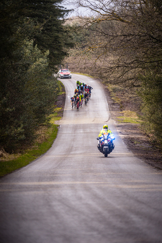 A group of cyclists racing down a country road as part of the Tour de France.