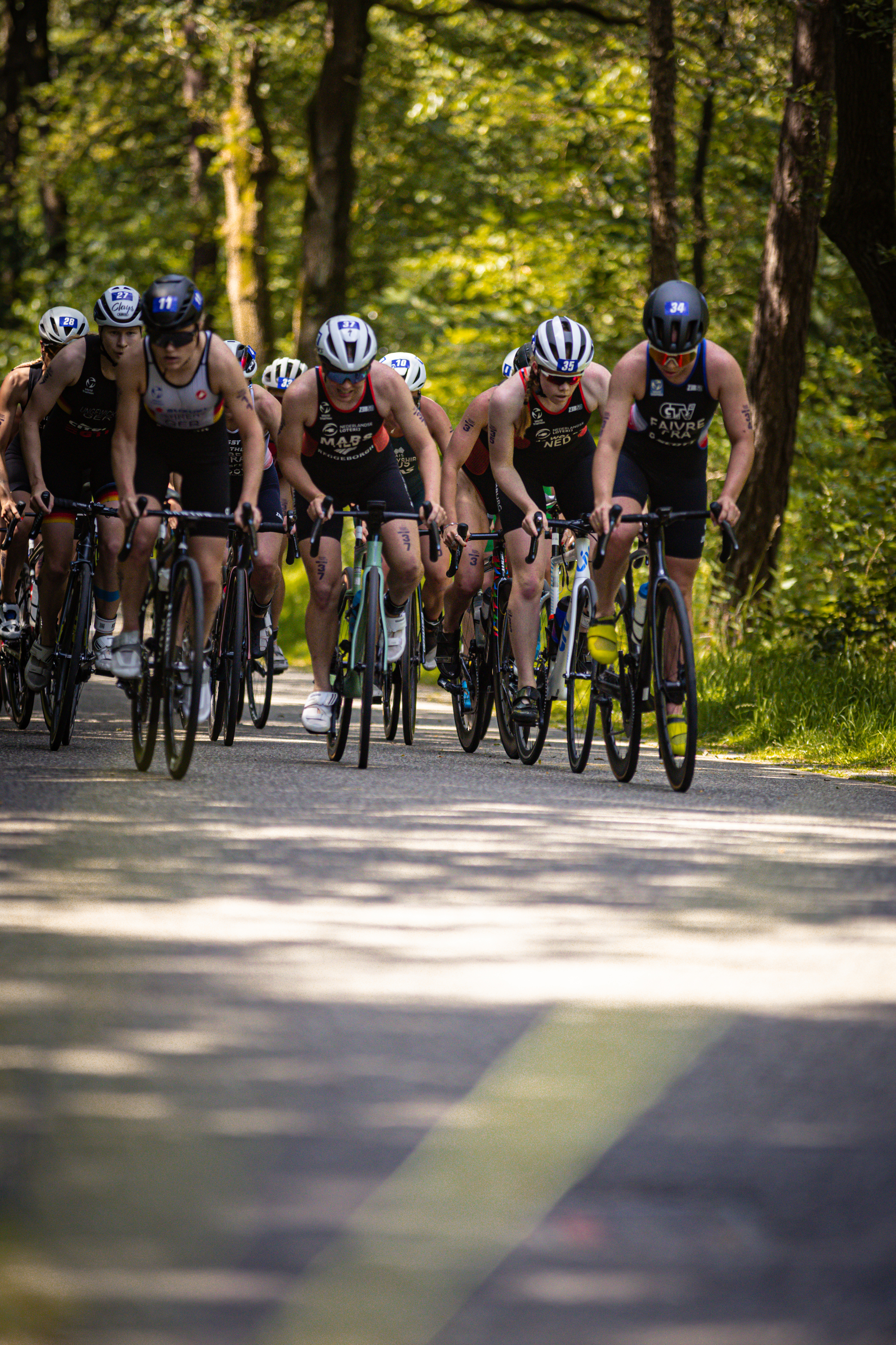 Six cyclists wearing ETU Elite Dames racing uniforms are riding down a road together.