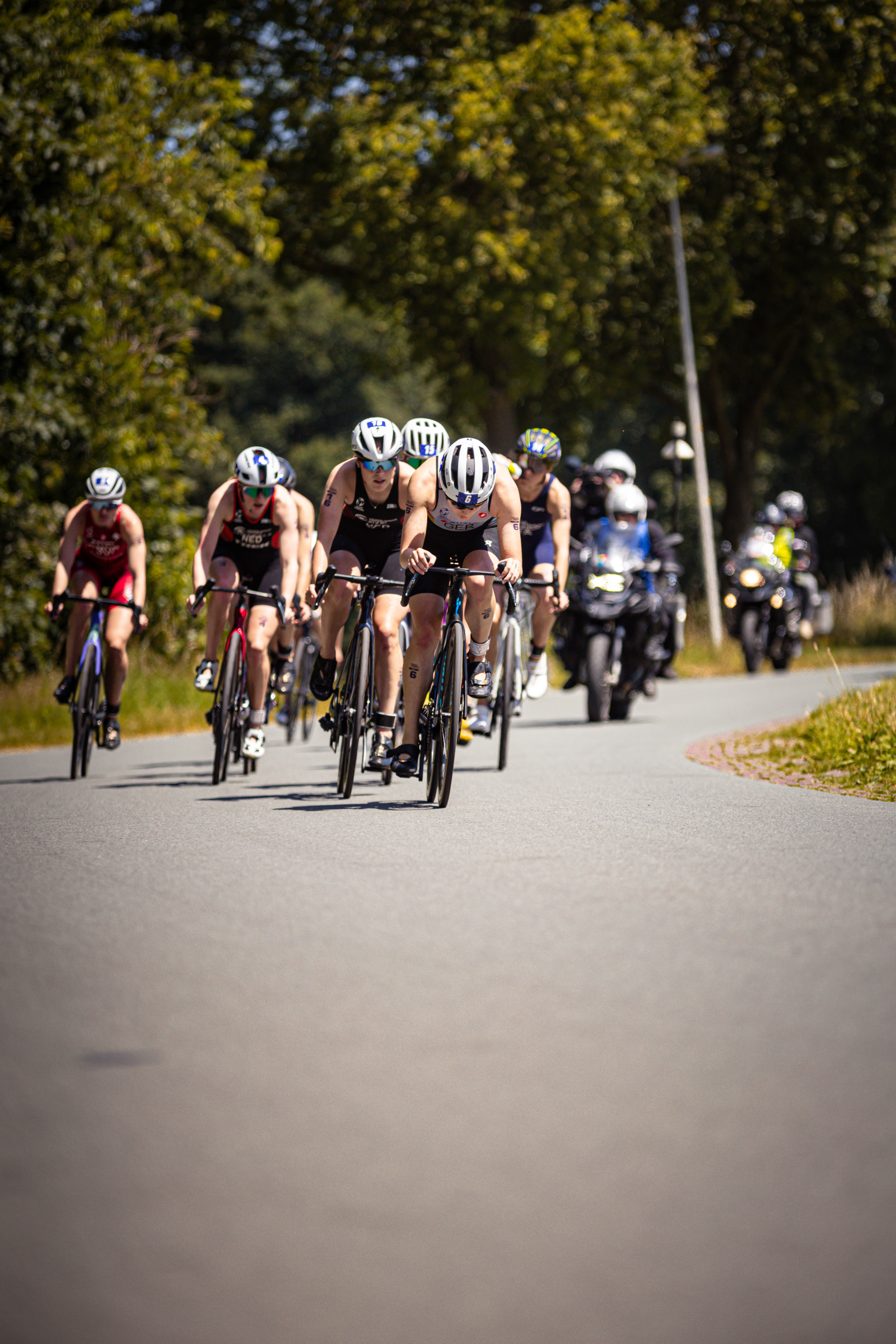 A group of cyclists in a race sponsored by ETU - Elite Dames, wearing helmets and racing gear.