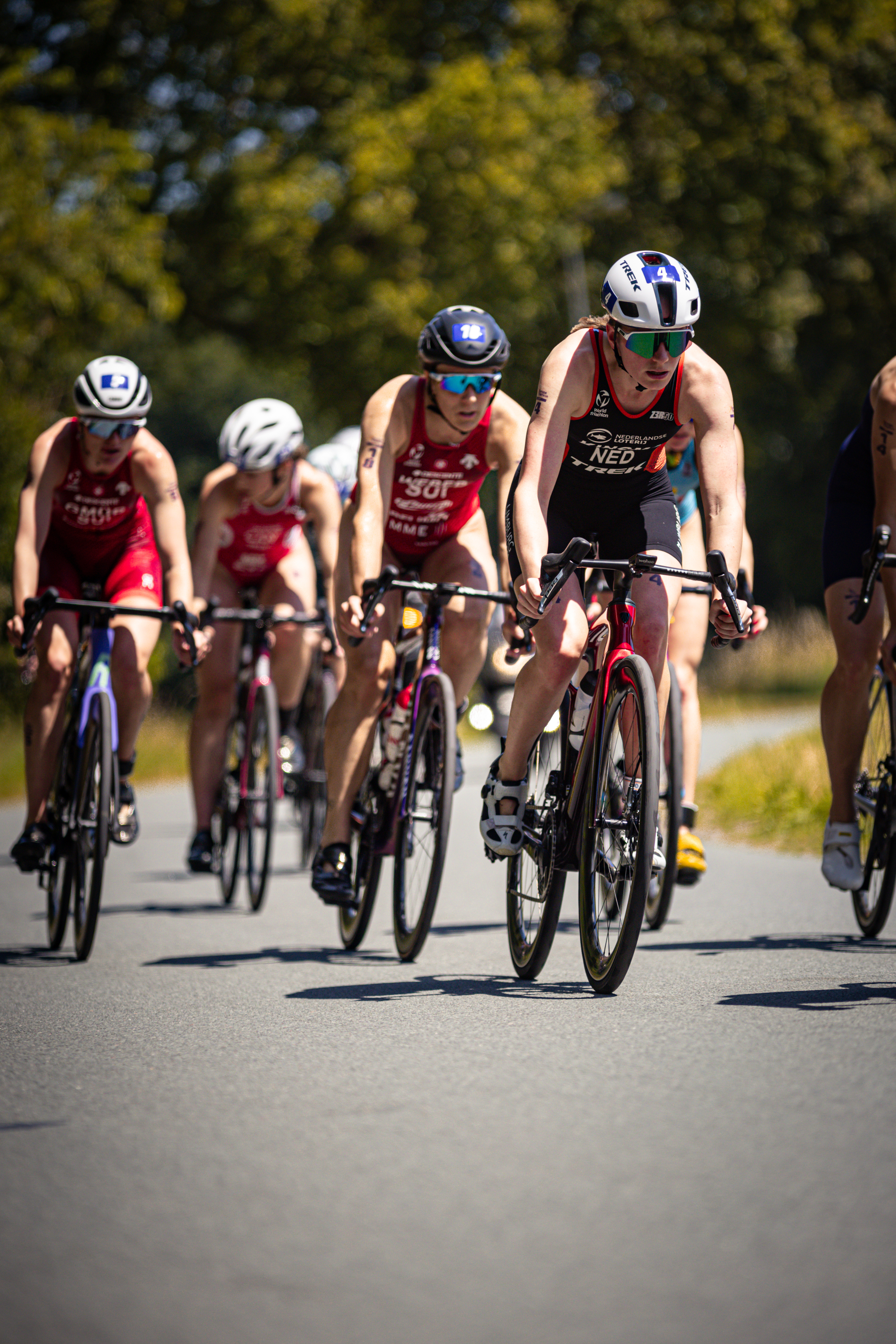 Group of female cyclists on a road with some wearing Elite Dames uniforms.