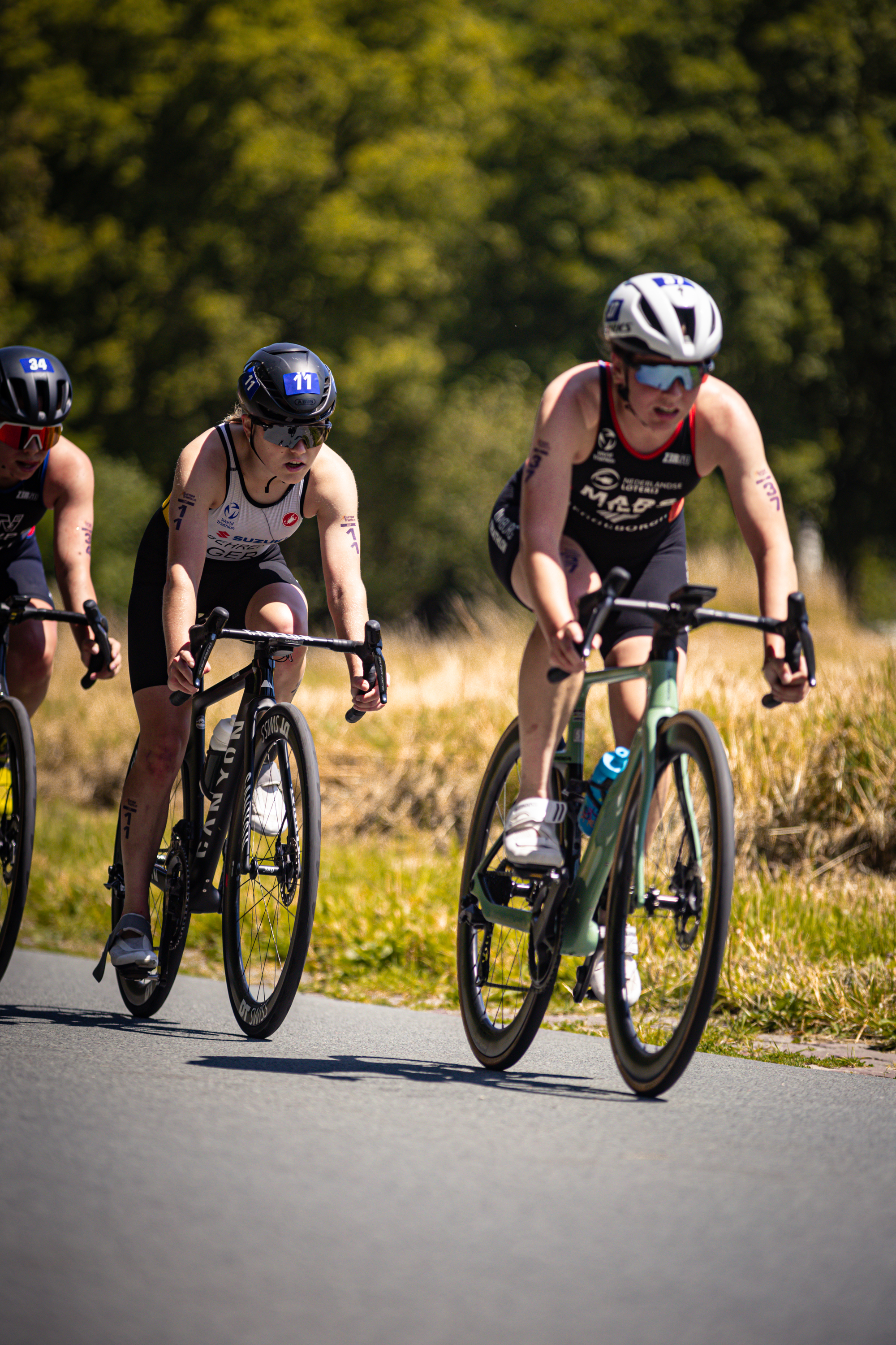 Two cyclists racing on a street with one of them wearing the brand ETU.