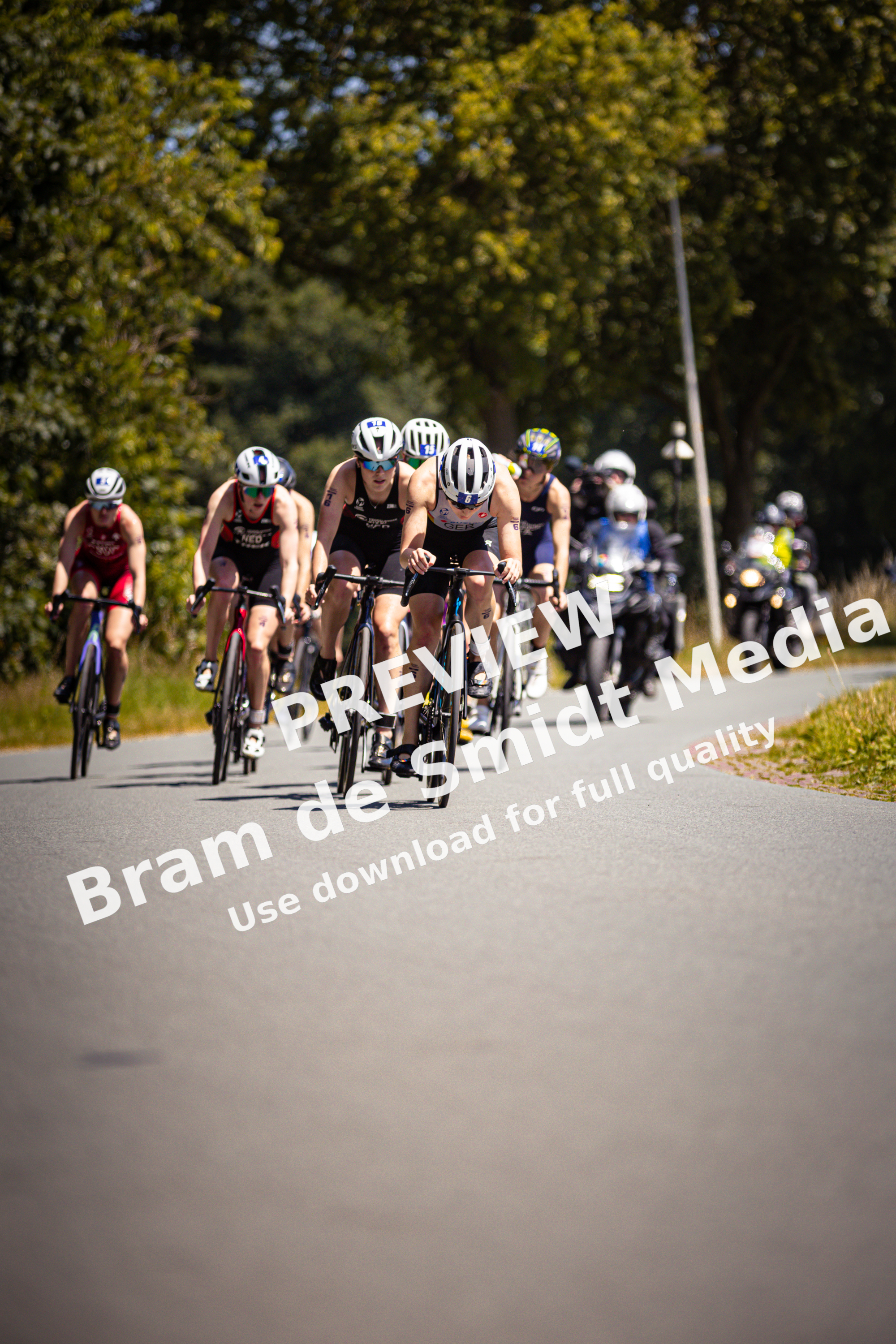 A group of cyclists in a race sponsored by ETU - Elite Dames, wearing helmets and racing gear.