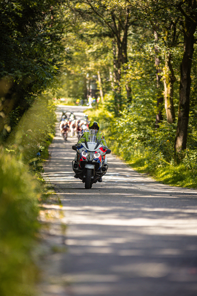 A group of bicyclists are on a road for a Triathlon race.