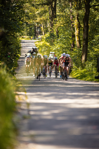 A group of cyclists riding down a road, sponsored by ETU - Elite Dames.