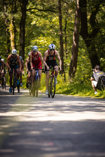 Elite cyclists are in a row as they ride down the street.