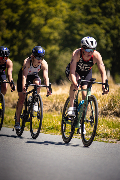 Two cyclists racing on a street with one of them wearing the brand ETU.