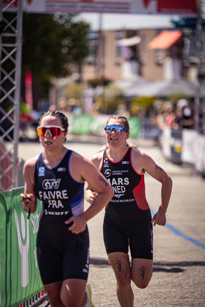 A woman running in a triathlon with the word Mars written on her uniform.