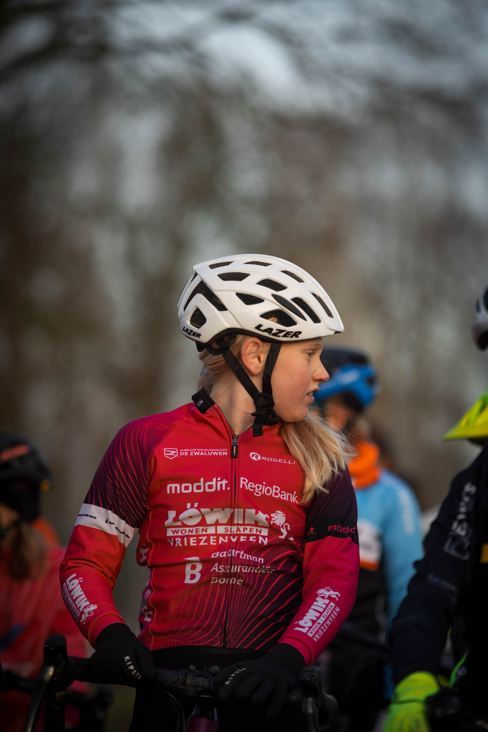 Two girls are wearing colorful outfits at the Cyclocross race.