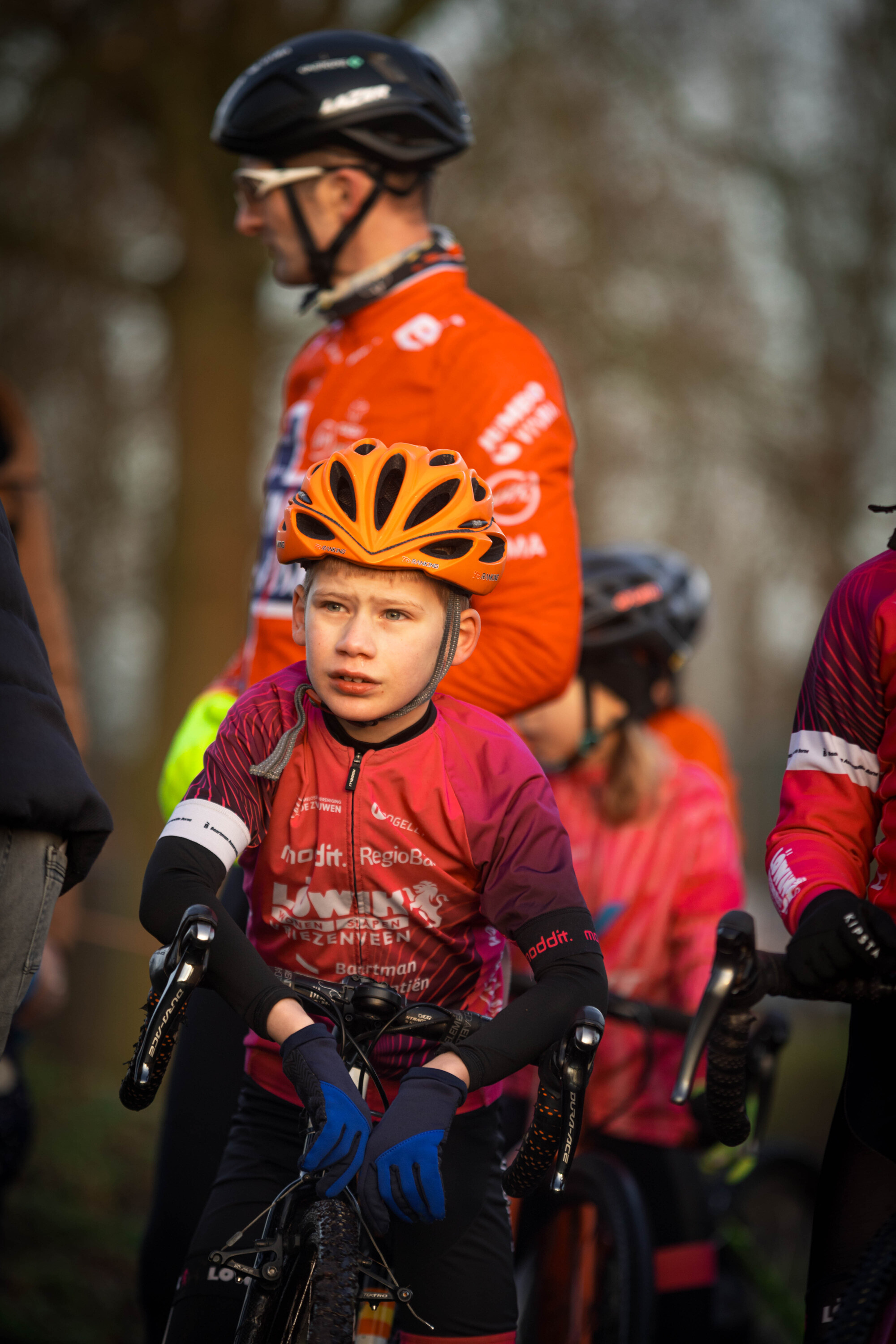 Three young boys on bikes wearing bike gear and one with a GOW shirt.