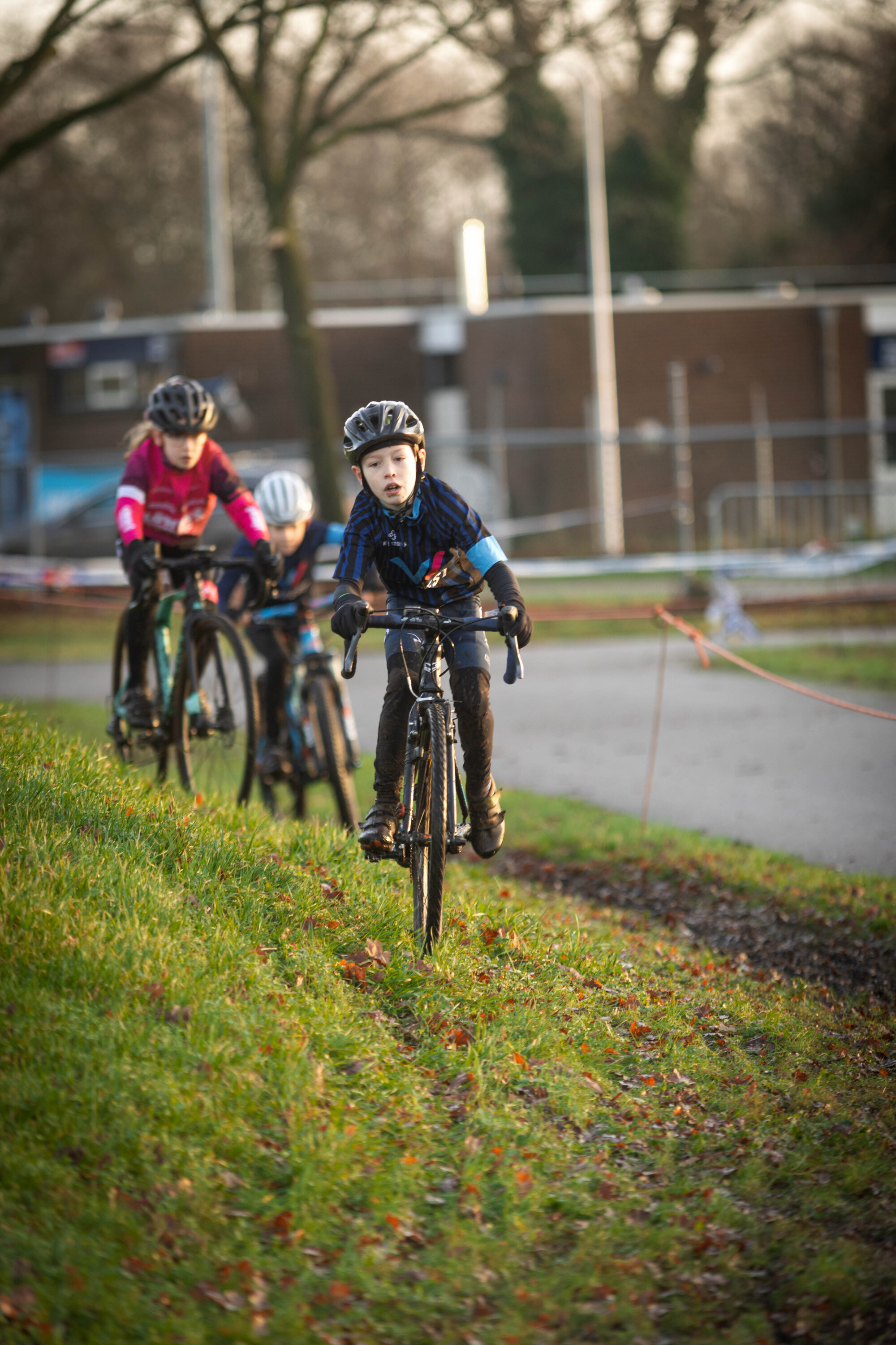 Two young children riding bikes in front of two other people.