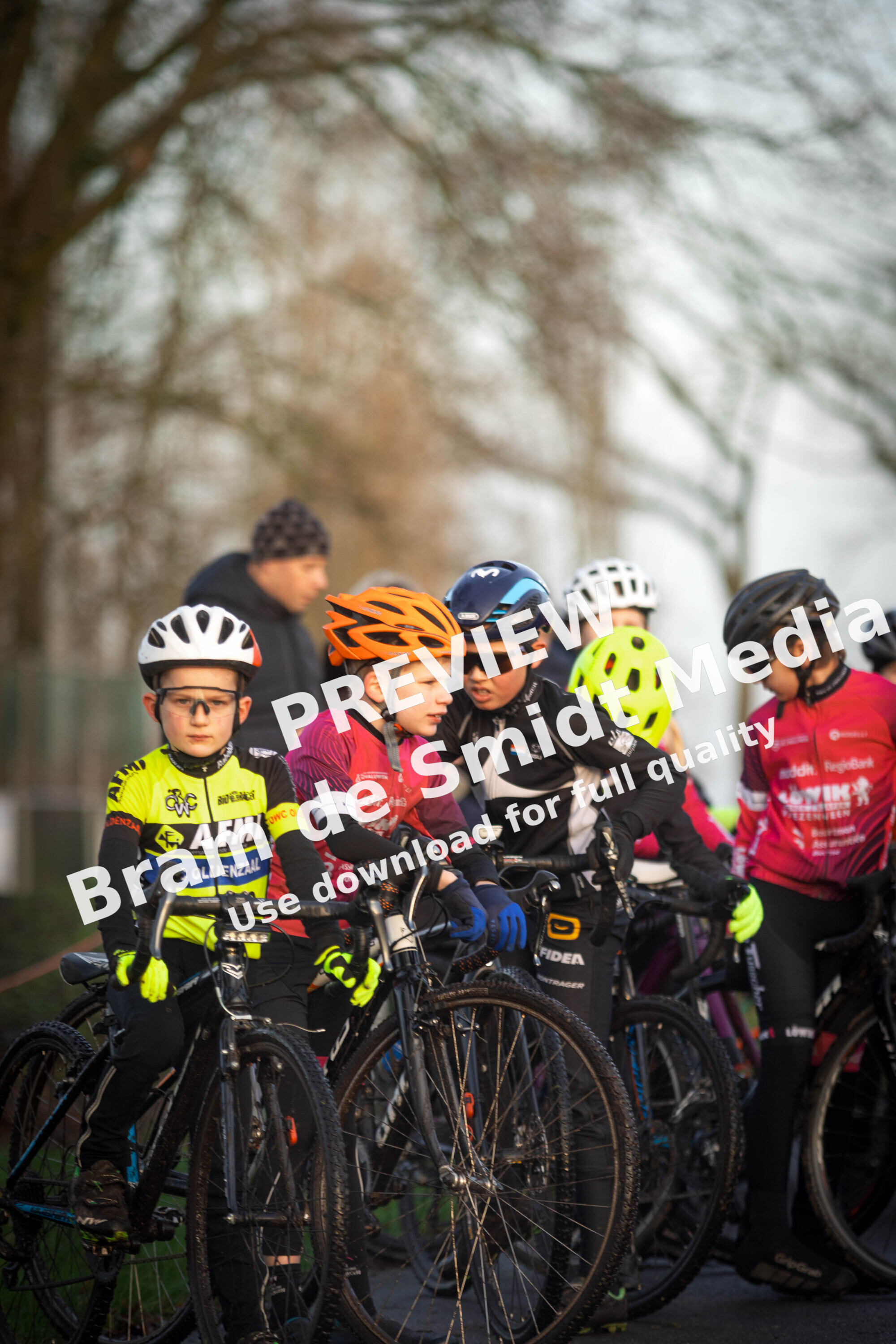 A group of young cyclists wearing helmets are preparing to compete in a race.