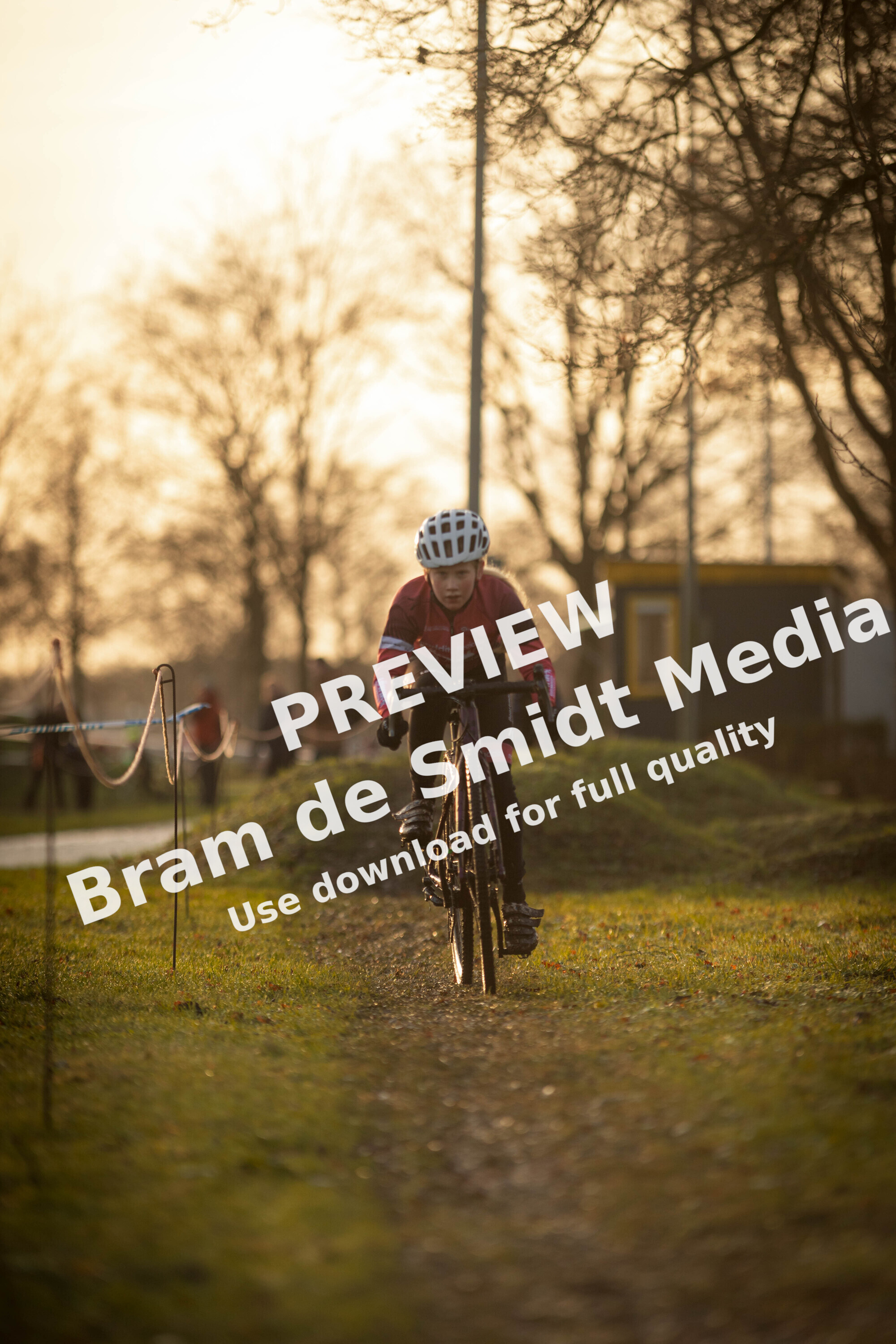 A kid wearing a helmet riding a bike on the trail.