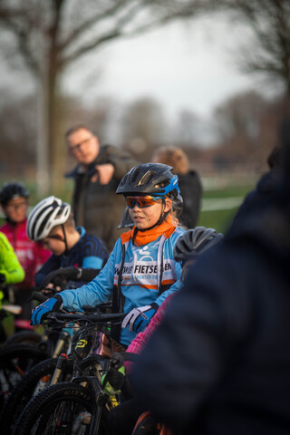 A person wearing a blue shirt that says "The Fresh Air" sits on a bicycle.