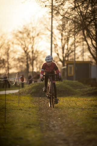 A kid wearing a helmet riding a bike on the trail.