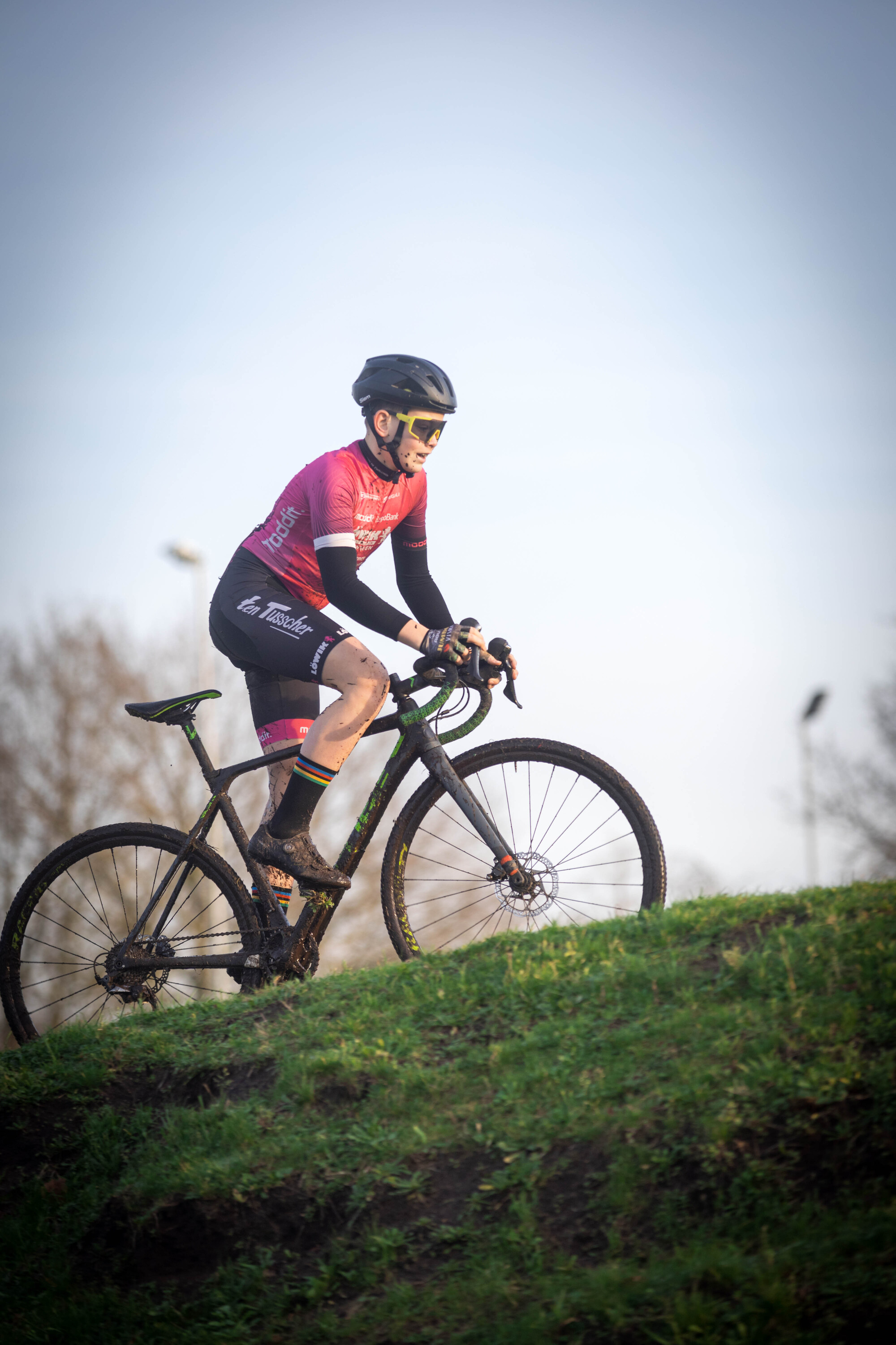 A person is riding a mountain bike on a grassy hill.