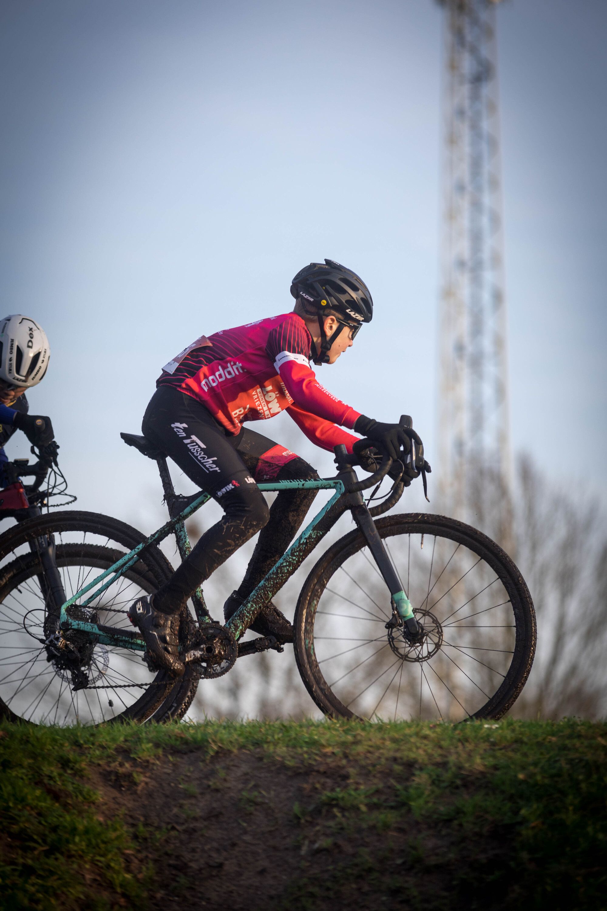 Two cyclists with GOW jerseys are riding their bikes.