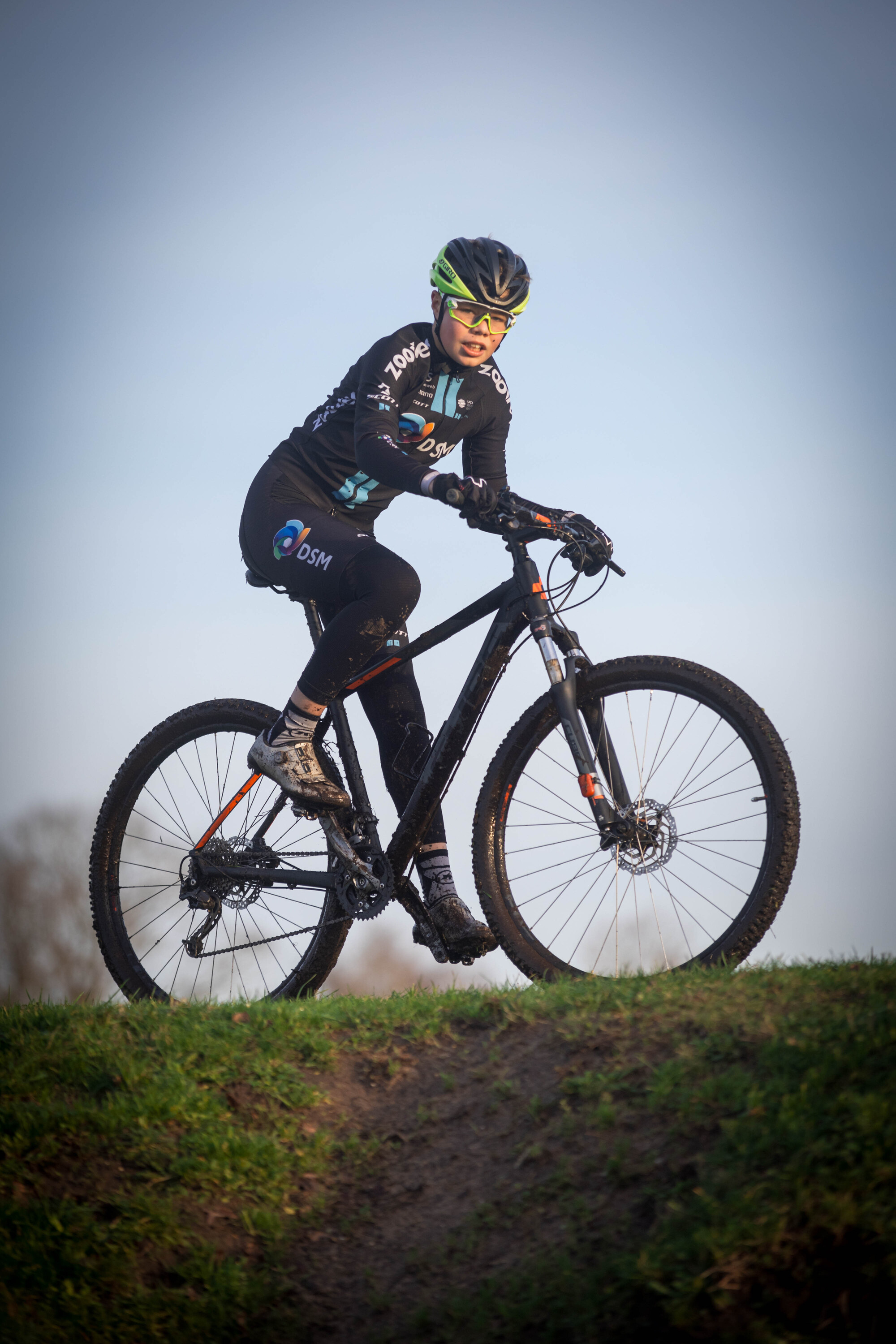 A young person is riding a black bicycle with a white number 3 on the handlebars.