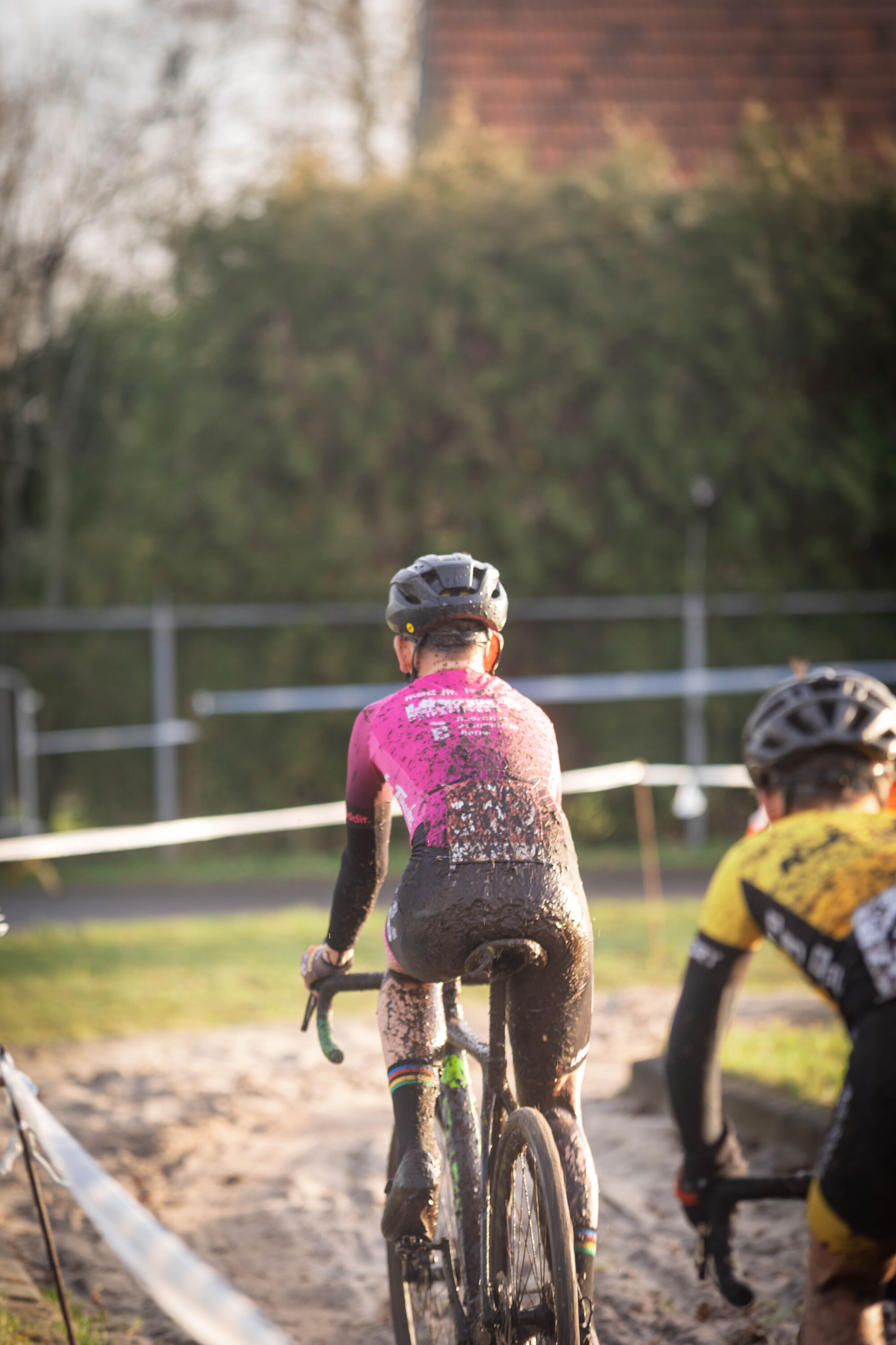 Two cyclists in a race, one with pink and the other yellow.