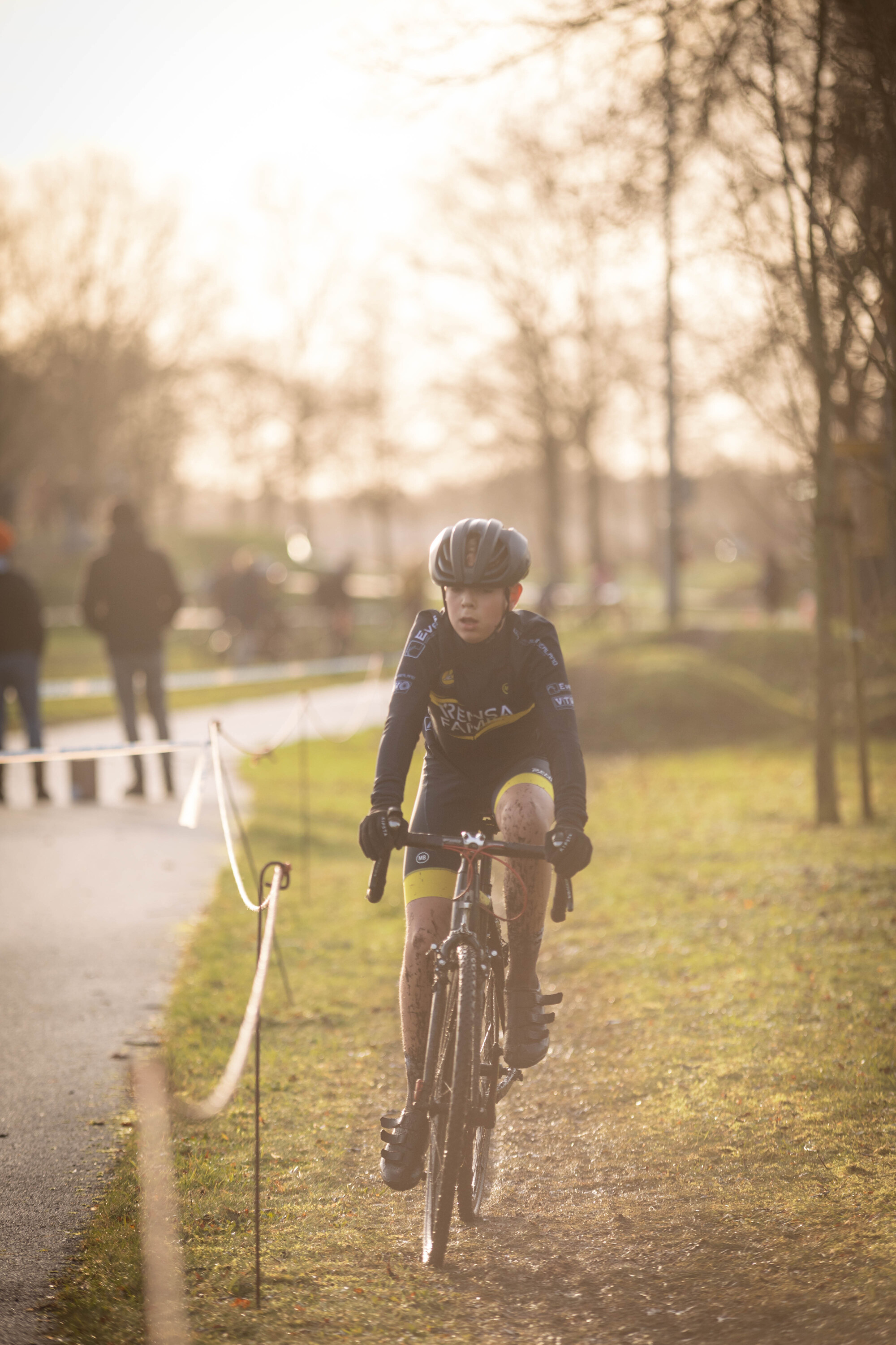 A young person is racing in a cyclocross competition.