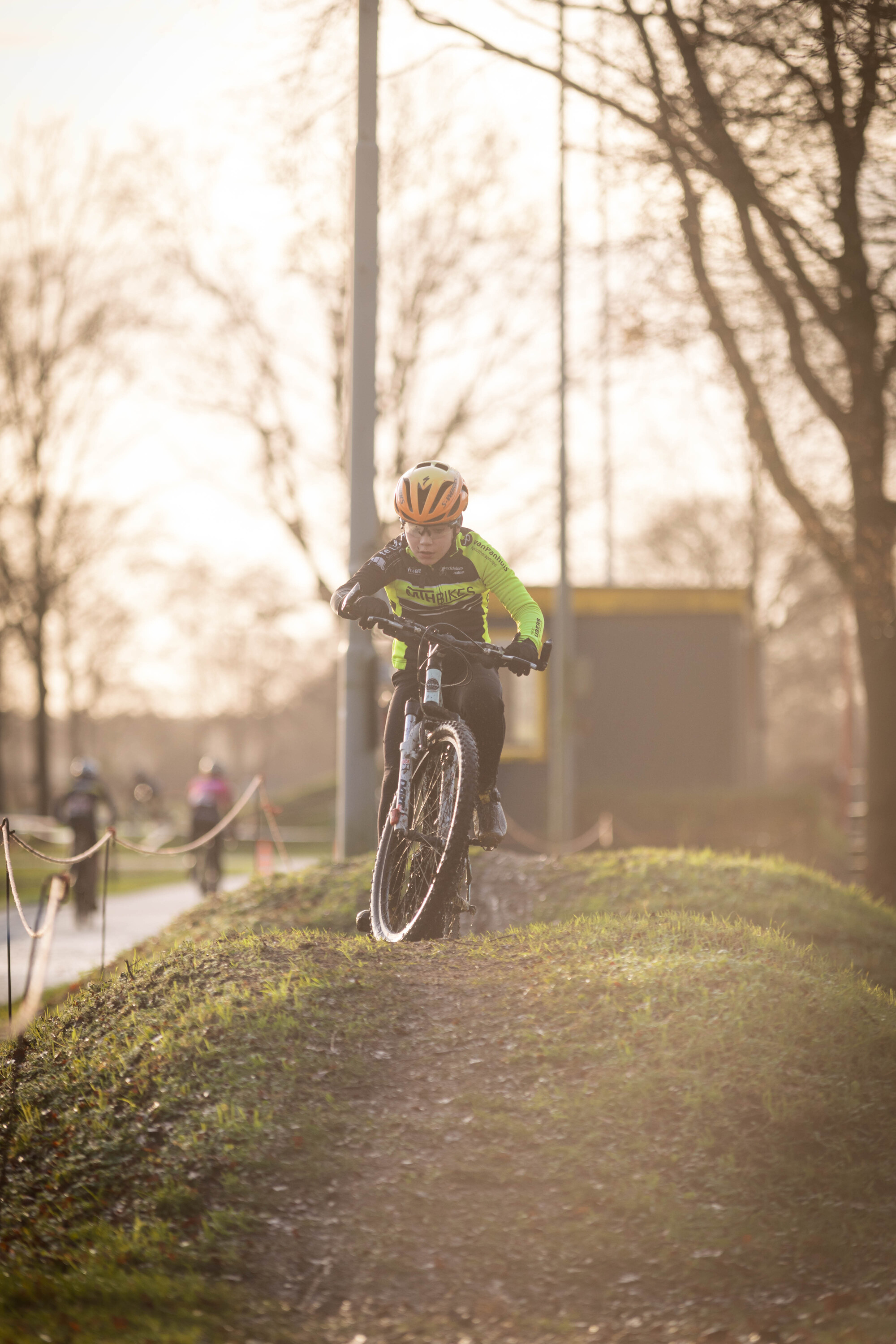 A bicycle rider is riding down a hill with the words Jeugd 3 on the back of their shirt.