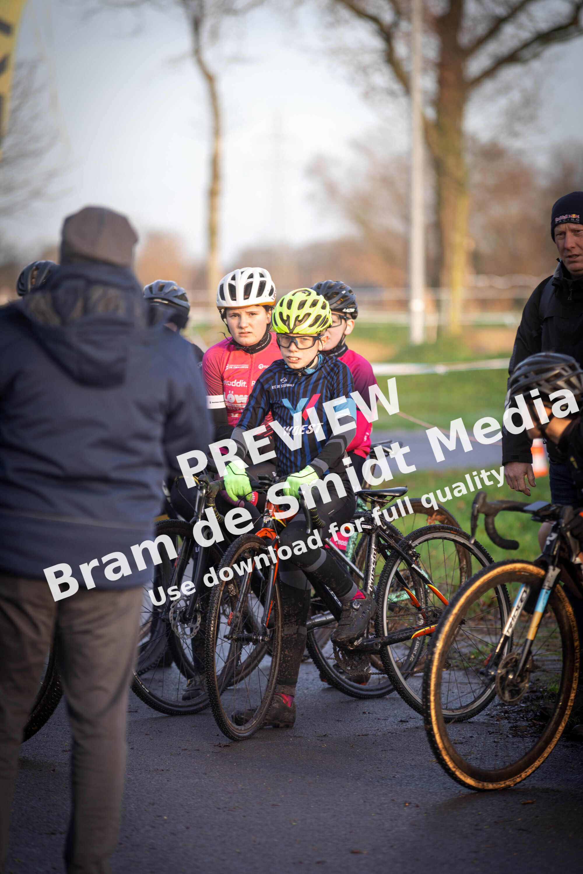 A group of young cyclists wearing helmets and riding bikes with one wearing a shirt saying GOW.