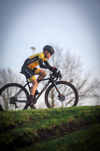 a man on a black and yellow bicycle wearing black and yellow shorts.