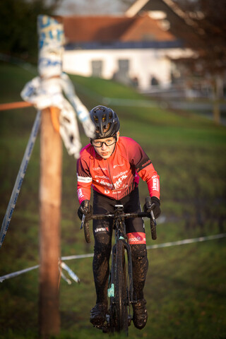 A person riding a bike wearing a red shirt that says "Grote Raaltee" on it.