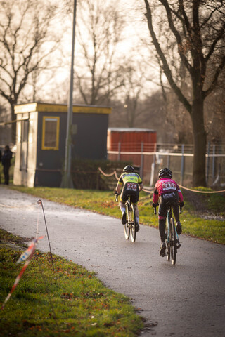 Two people riding bikes with their backs to the camera.