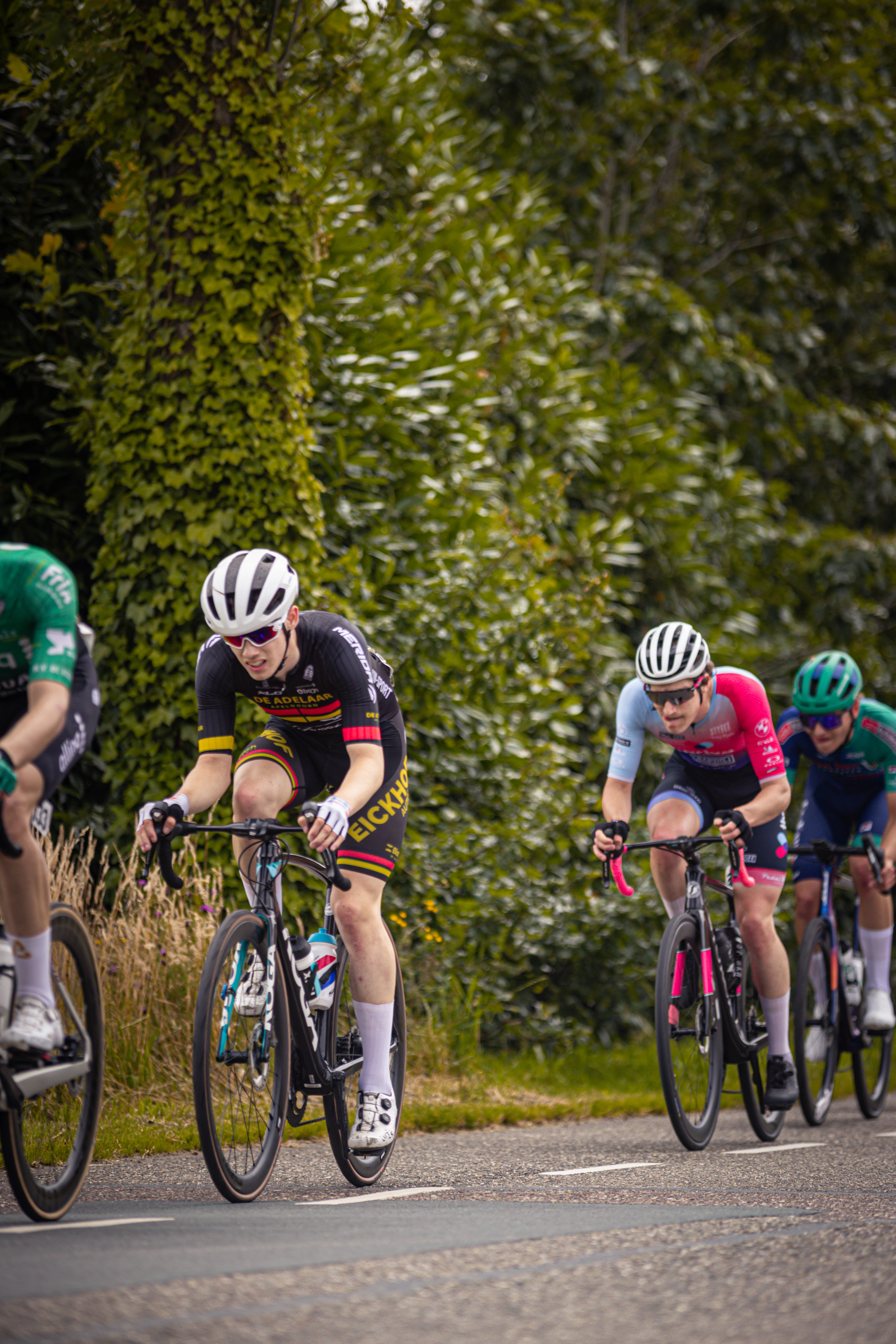 Four cyclists racing on a road for the Midden Brabant Poort Omloop race.