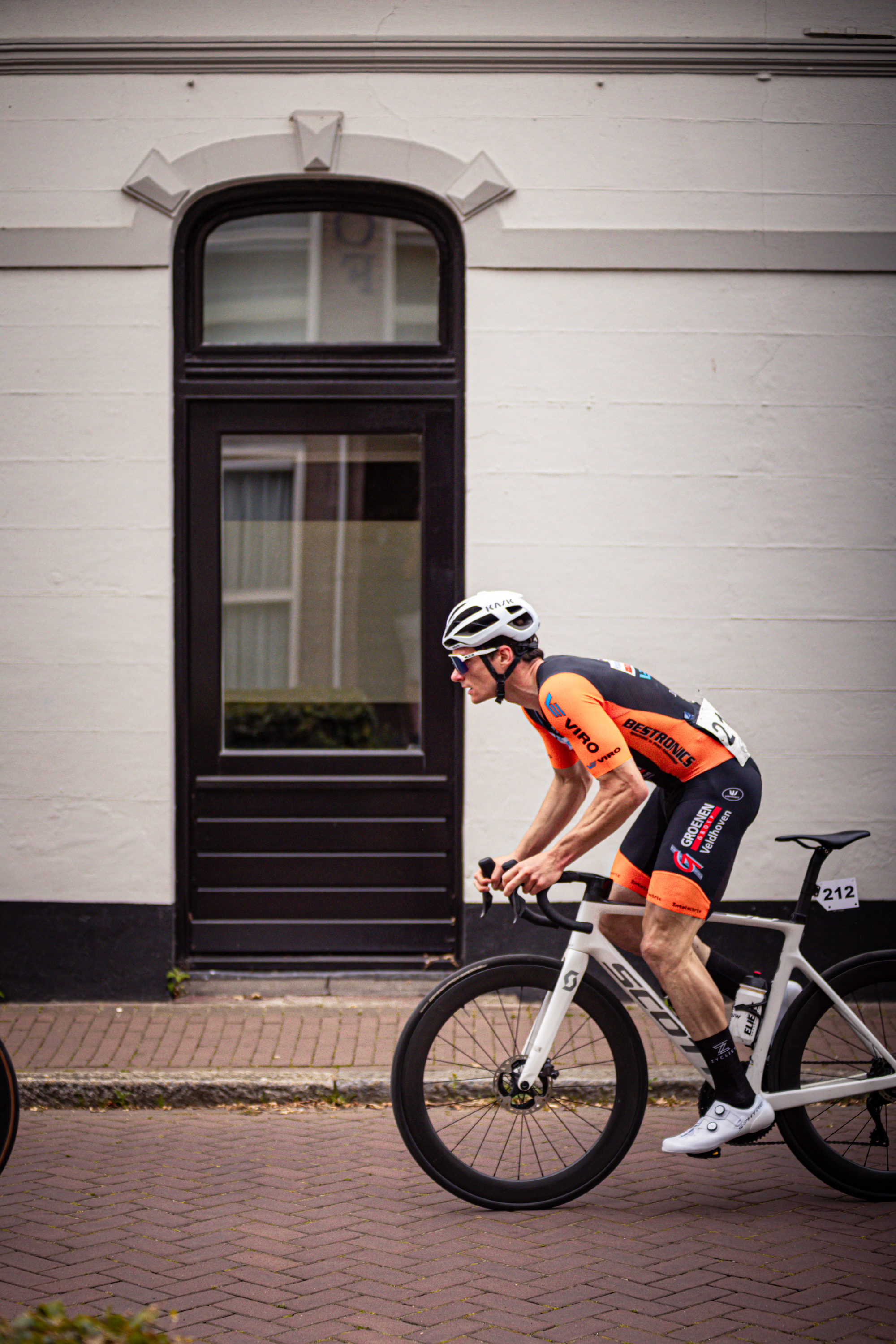 A cyclist in a black and orange uniform with the number 9 on it.