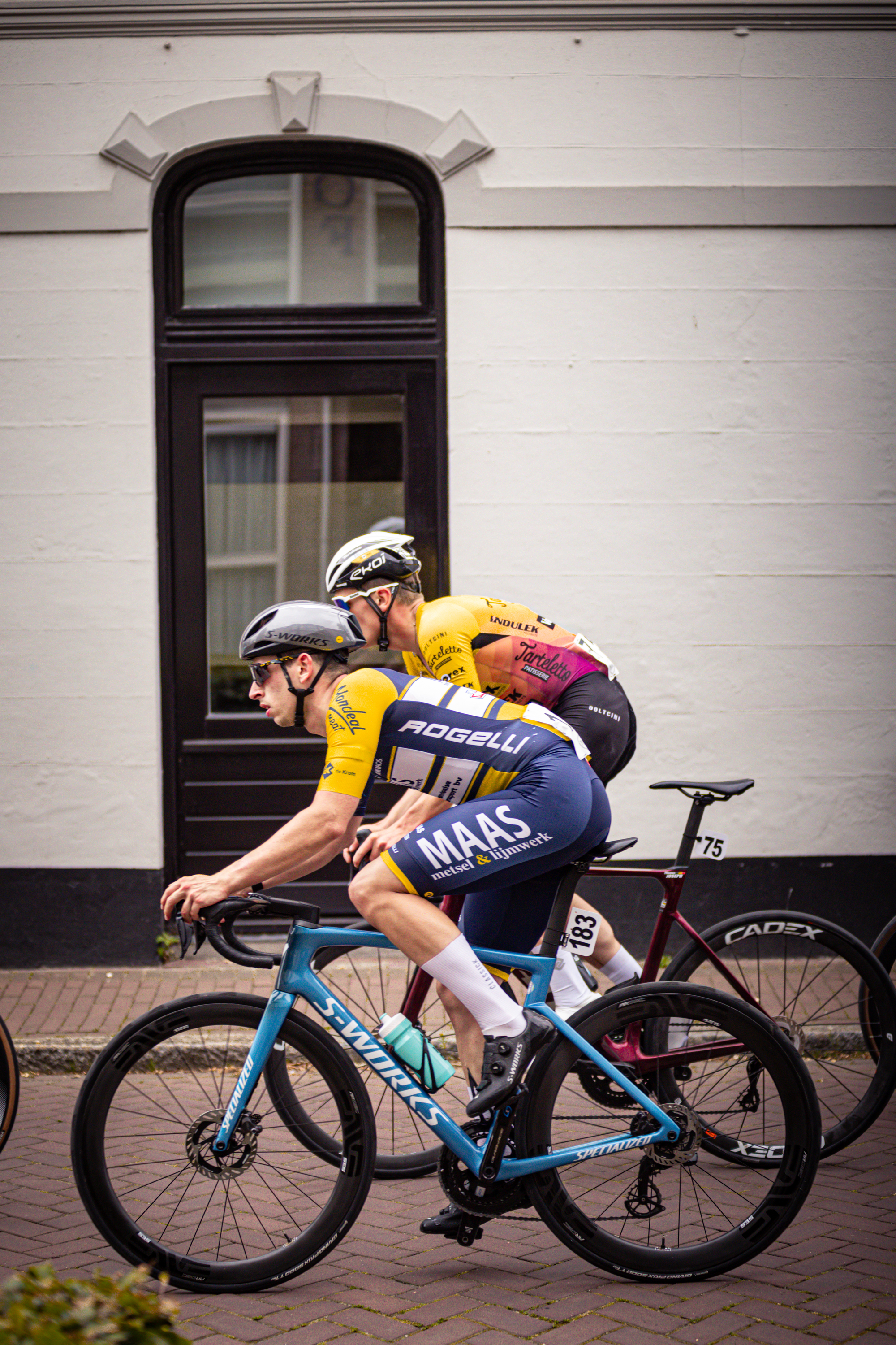 Two cyclists are racing in a race that is taking place during the Midden Brabant Poort Omloop.