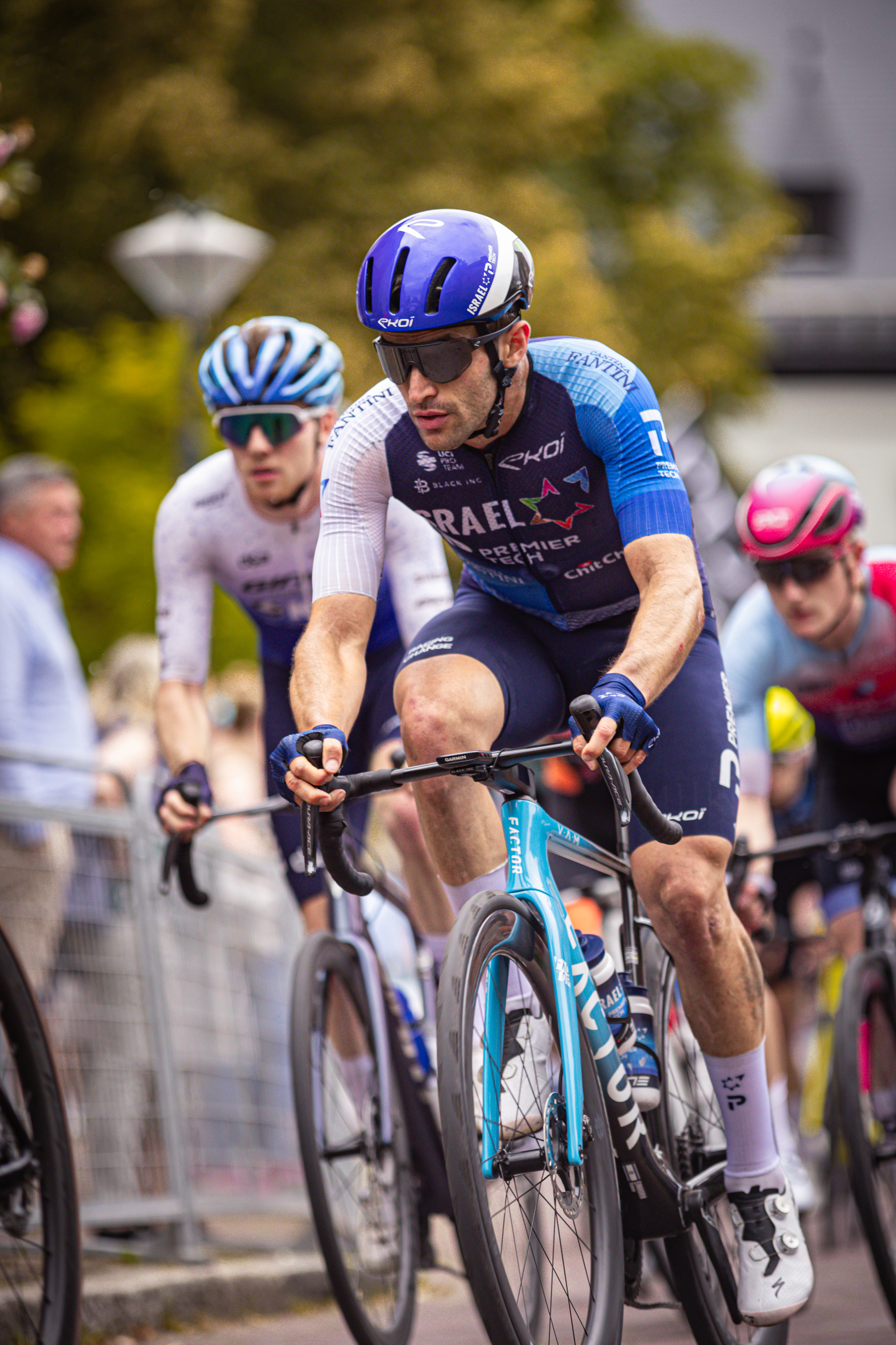 A group of men racing on bicycles, with the blue and white uniform in the middle.