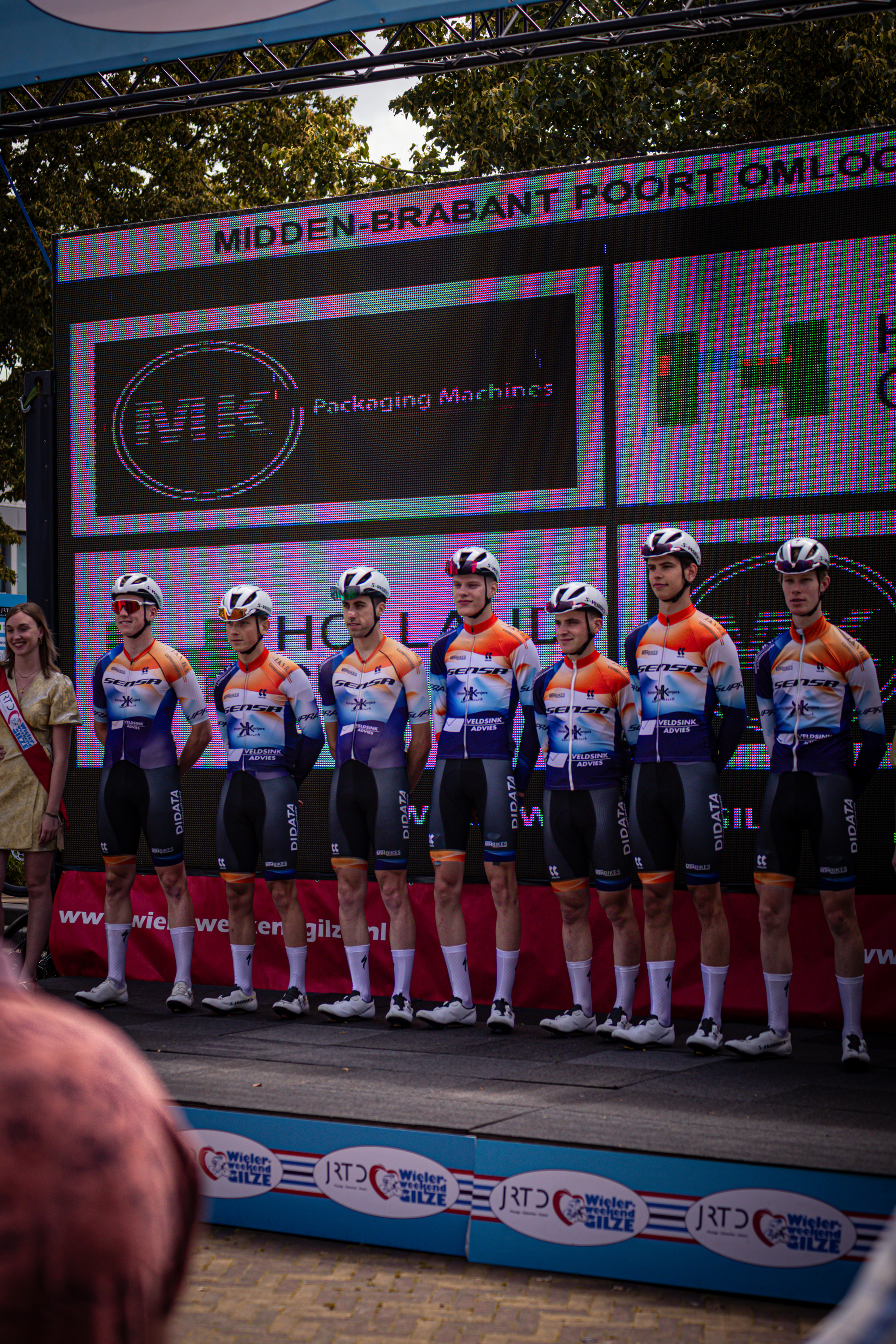 A group of cyclists standing in a line up to race.