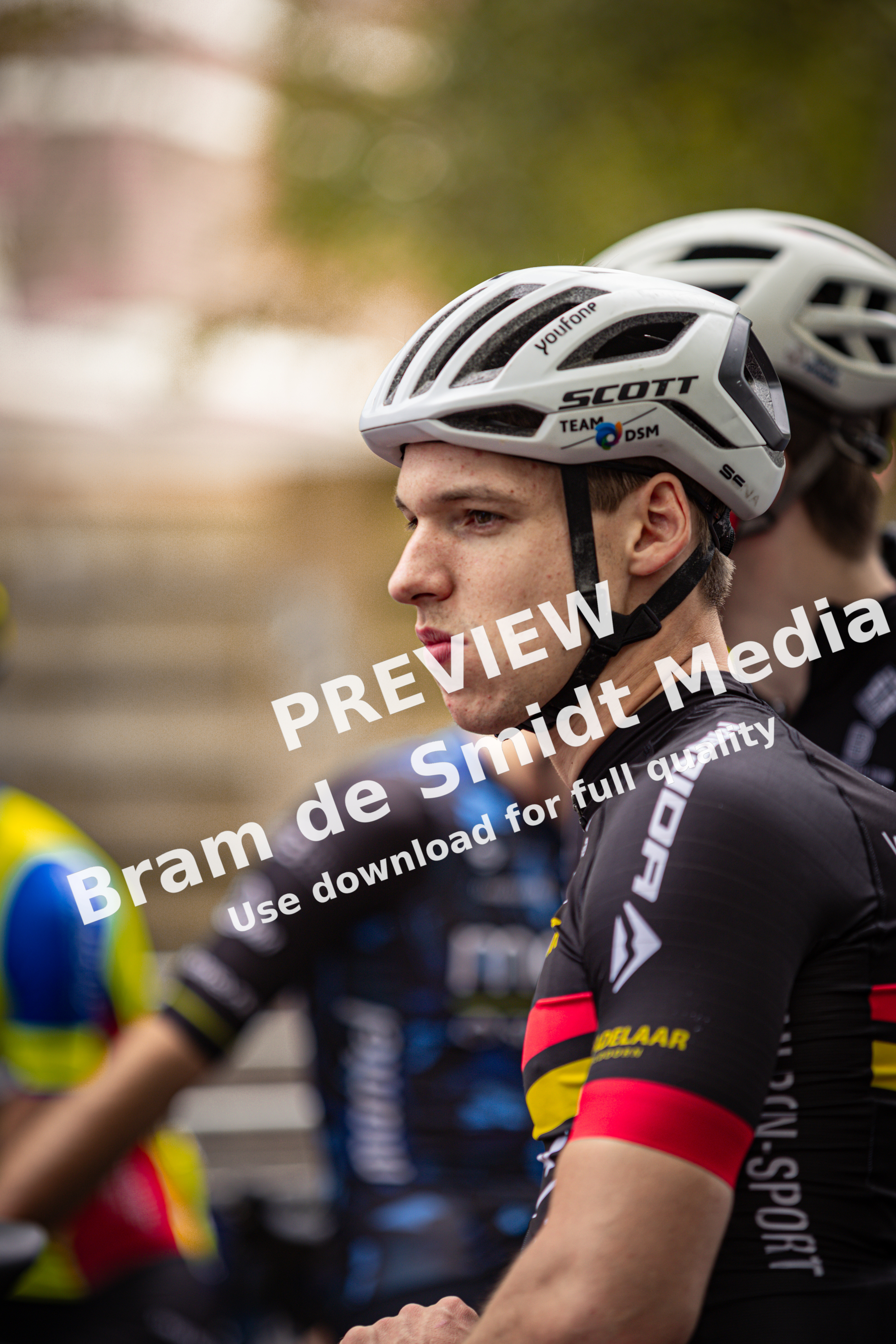 A cyclist with his head turned to the side, wearing a white Spuit helmet.