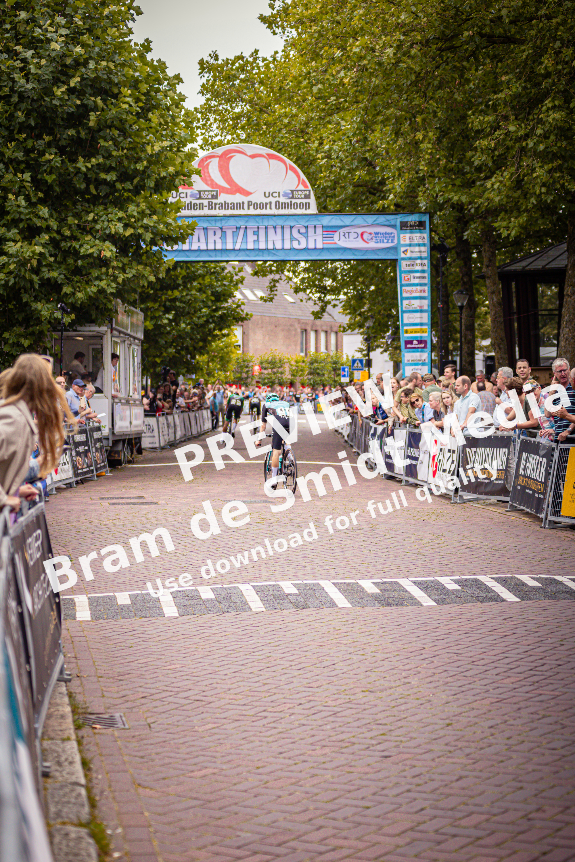 A cyclist crosses the Midden Brabant Poort Omloop finish line.