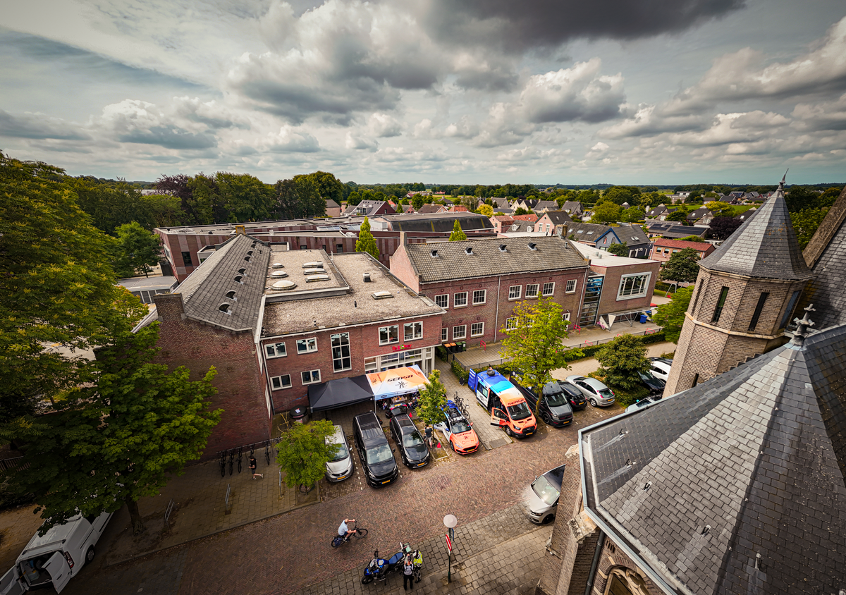 A large parking lot in front of a building called "Midden Brabant Poort Omloop".