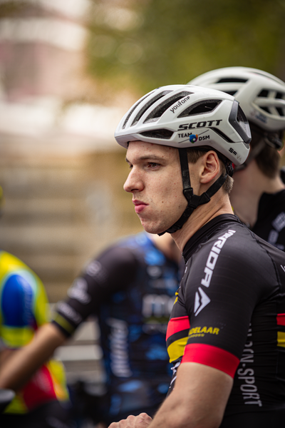 A cyclist with his head turned to the side, wearing a white Spuit helmet.