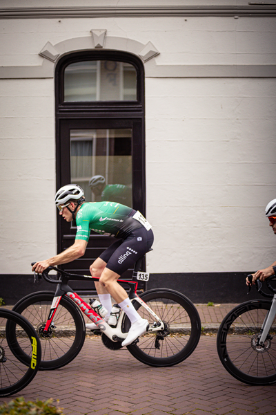 Two cyclists race through a quaint European village.