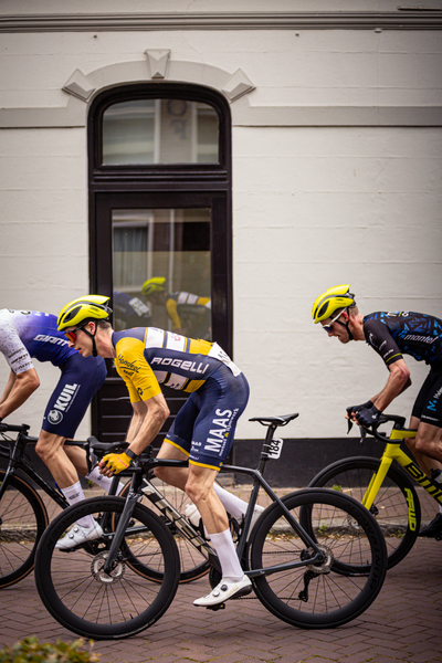 Three men on bicycles wearing yellow helmets and matching outfits.