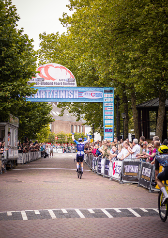 A cyclist crossing the finish line at Midden Brabant Poort Omloop in 2024.