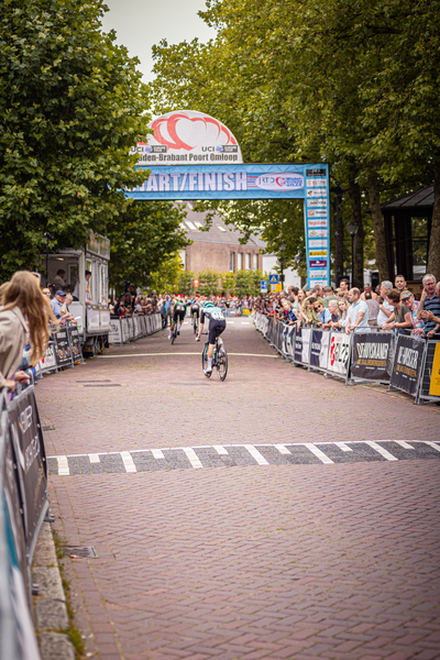 A cyclist crosses the Midden Brabant Poort Omloop finish line.