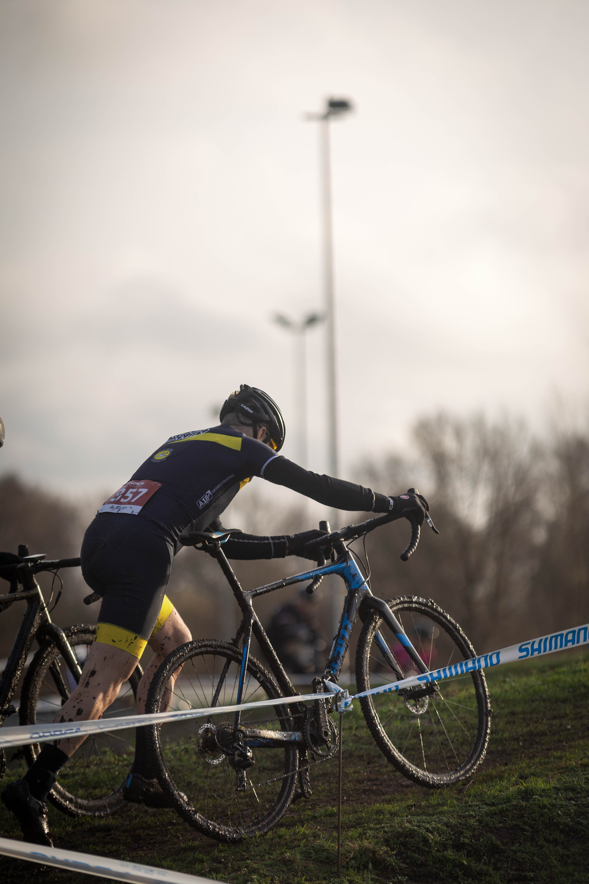 A man is riding a black and blue bike during the Masters cyclocross event in 2023.