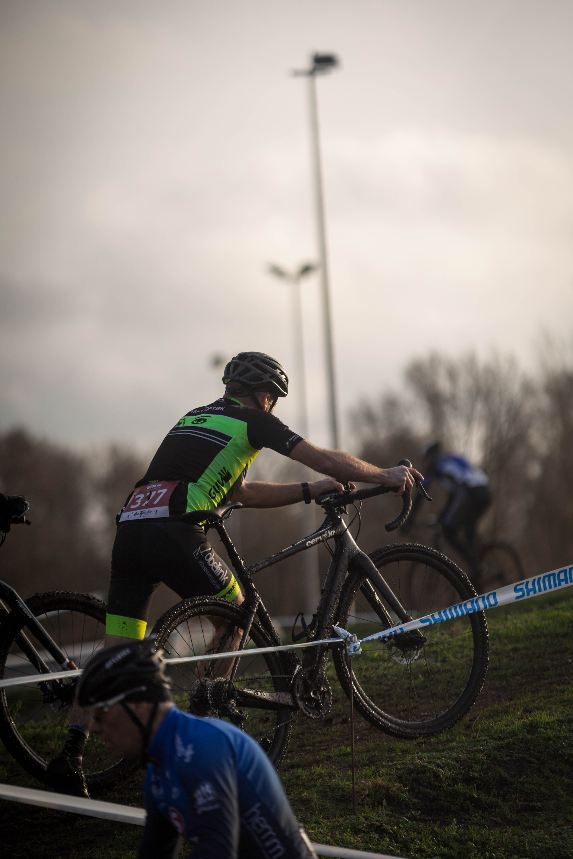 A man is riding a bike while wearing a shirt that says Masters.