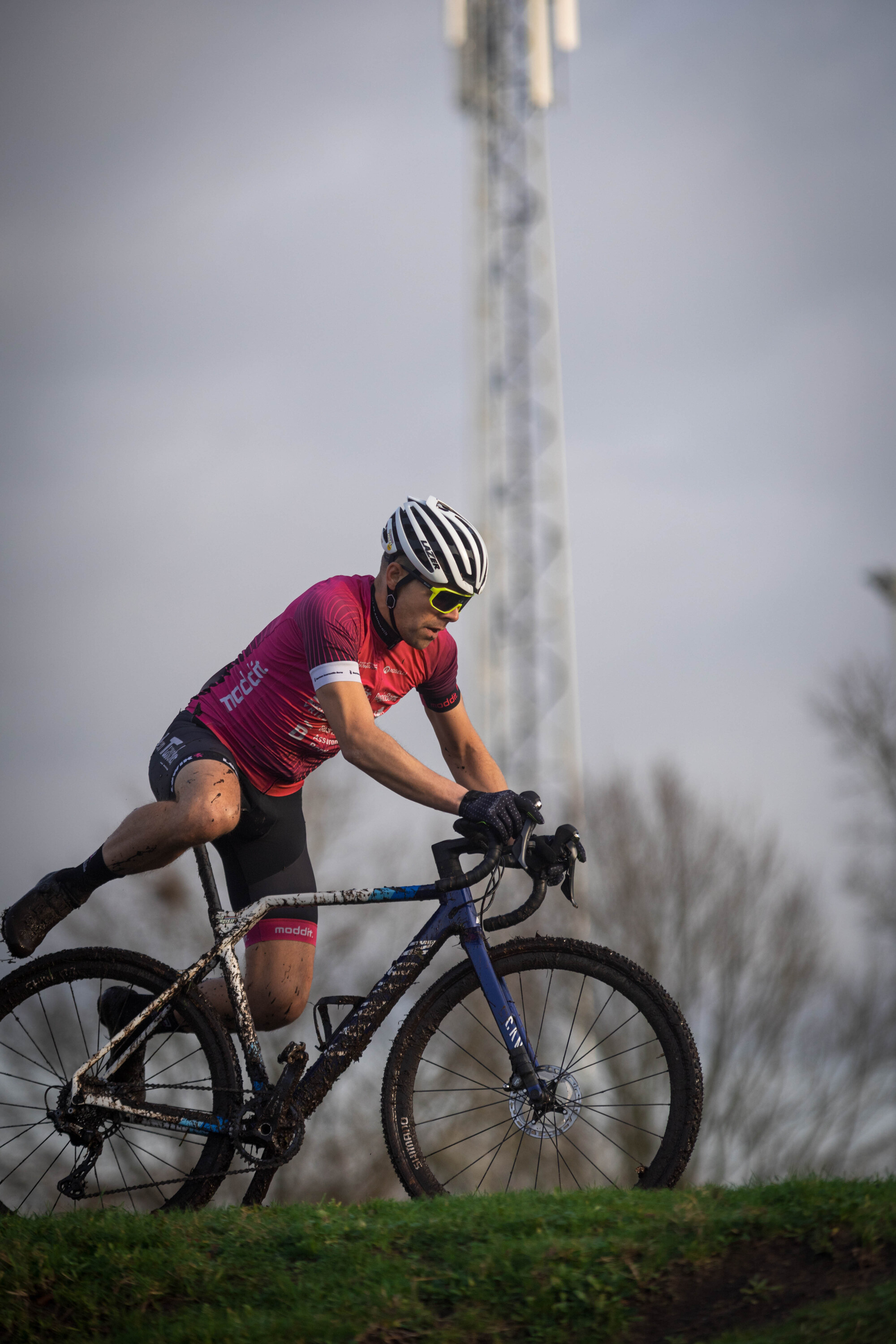 A man in a black and white helmet on a blue mountain bike.