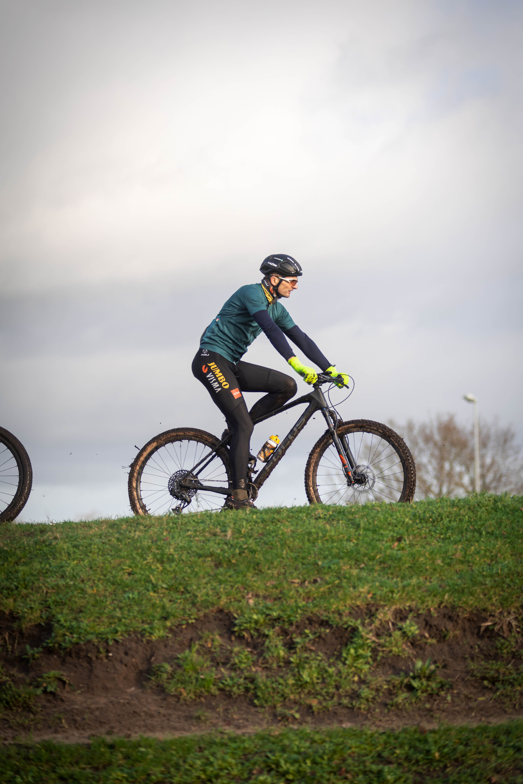 A man in a blue shirt and black pants riding a mountain bike.