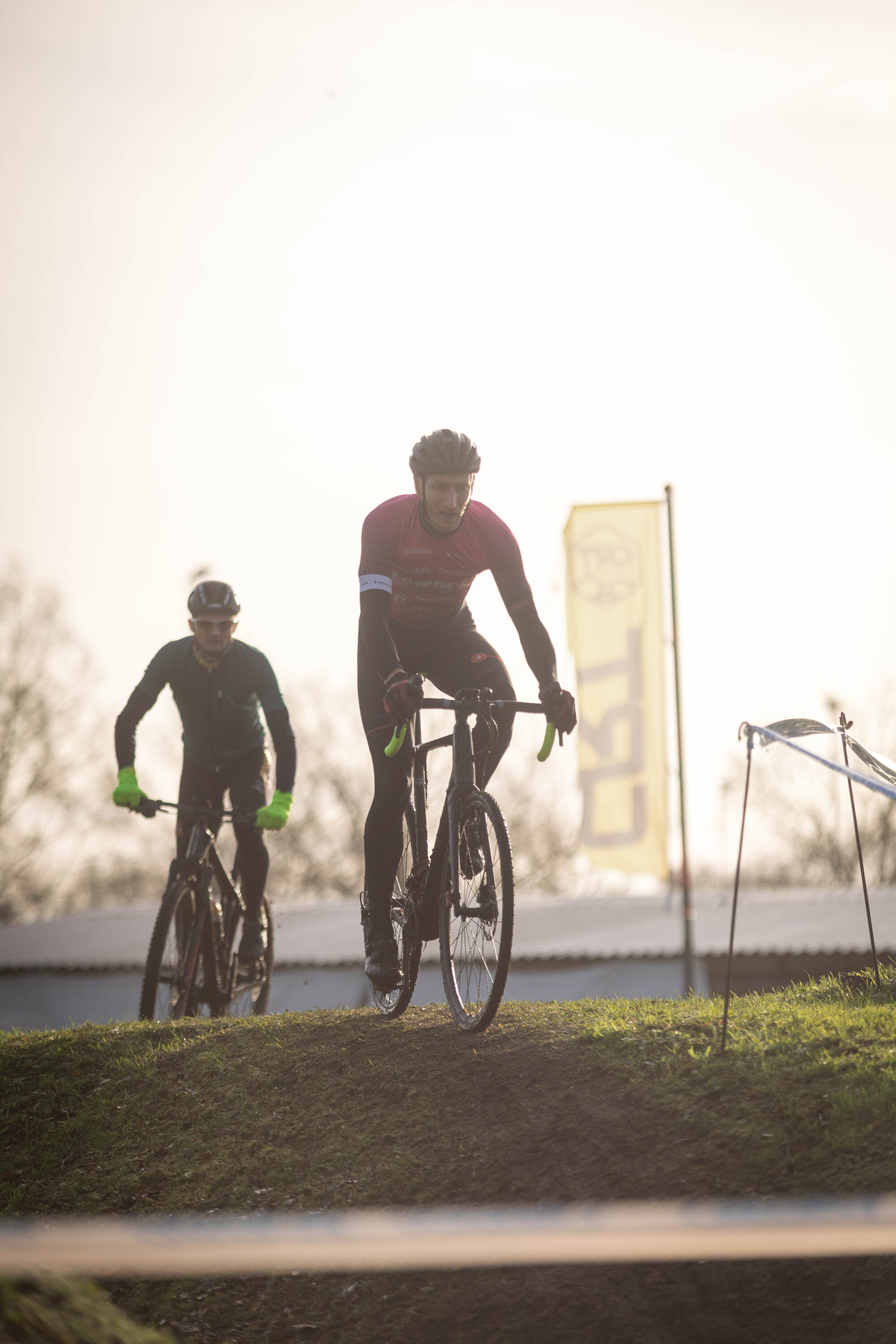 Two men are racing on a grassy hill during the Cyclocross Masters race in 2023.