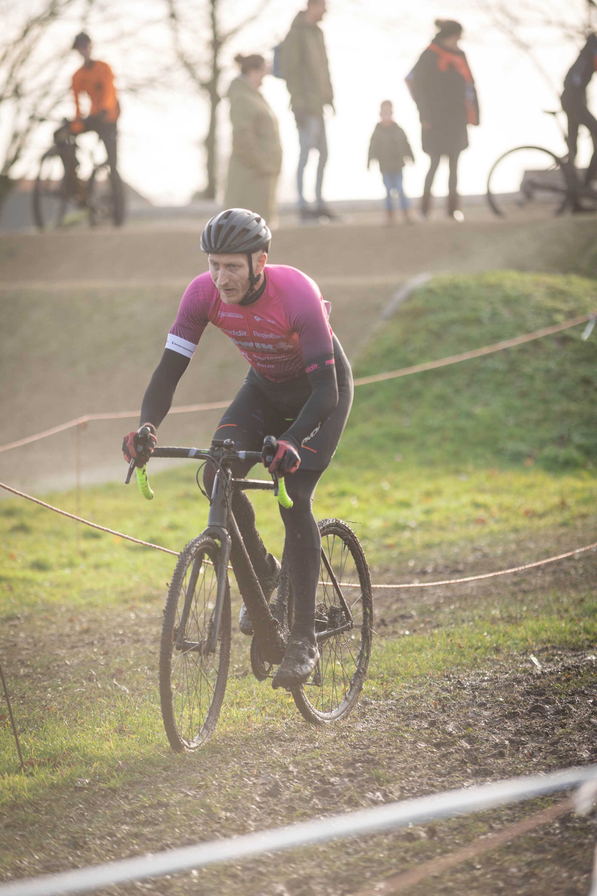 A person riding a black bike wearing a pink shirt that says "go" on it.