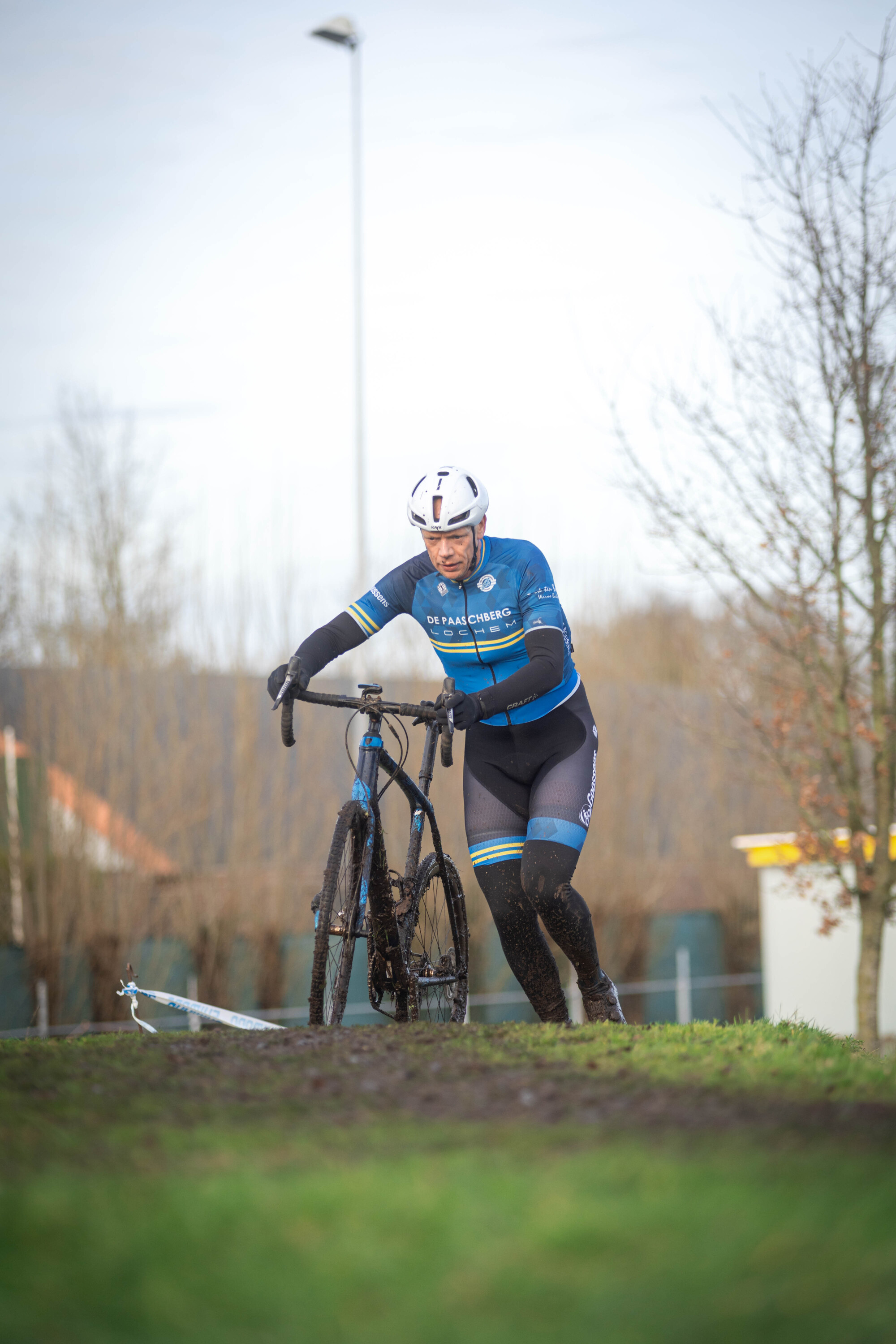 A person in a blue and black jacket is riding a bicycle.